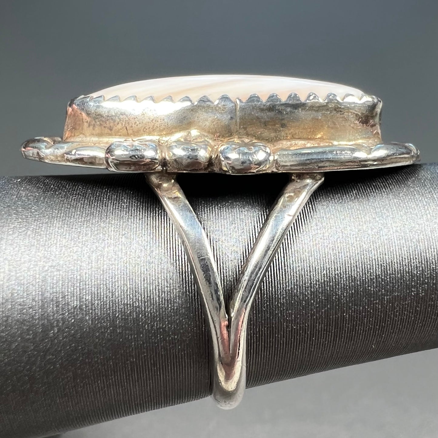 A Southwest style silver ring set with a faint pink mother of pearl stone.