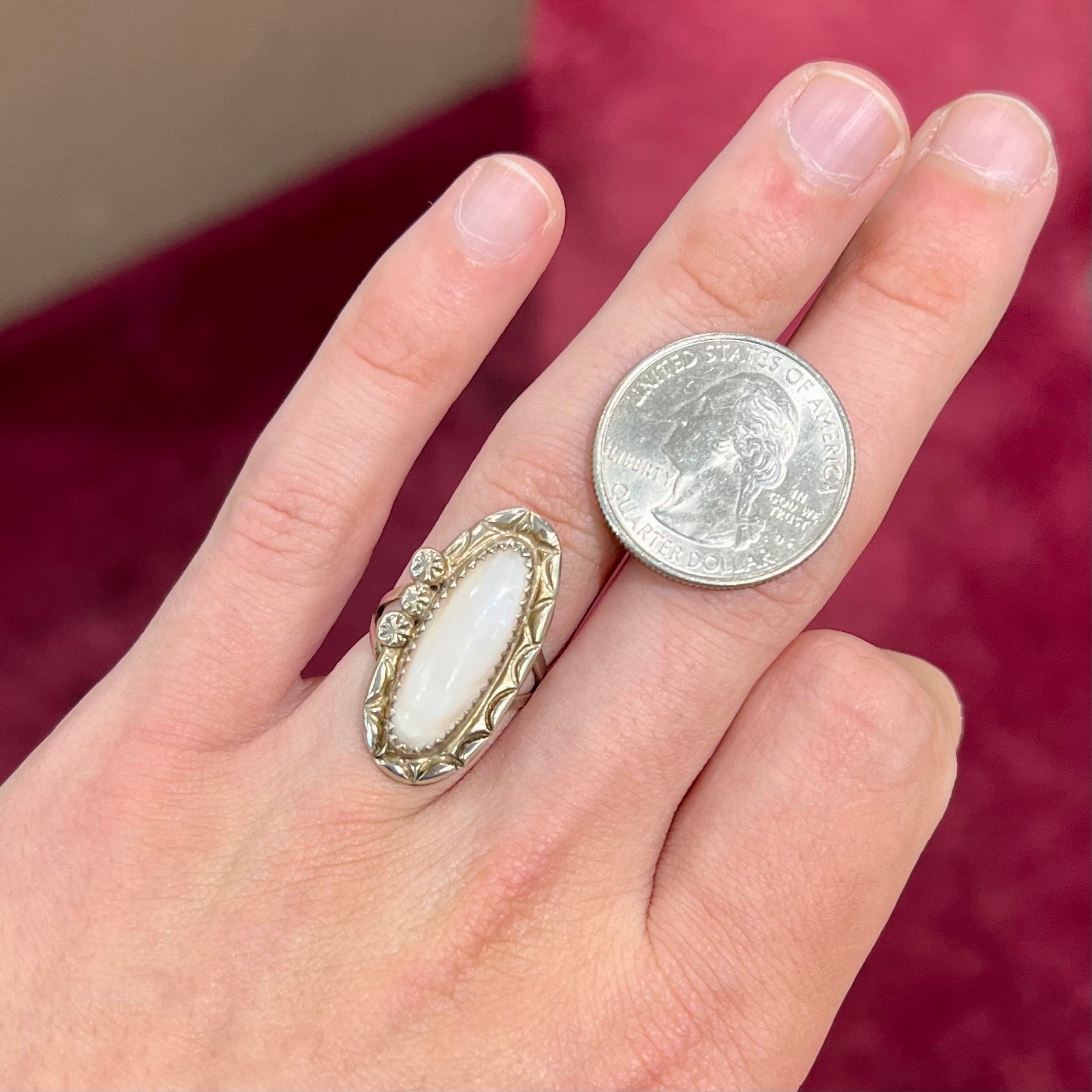 A Southwest style silver ring set with a faint pink mother of pearl stone.