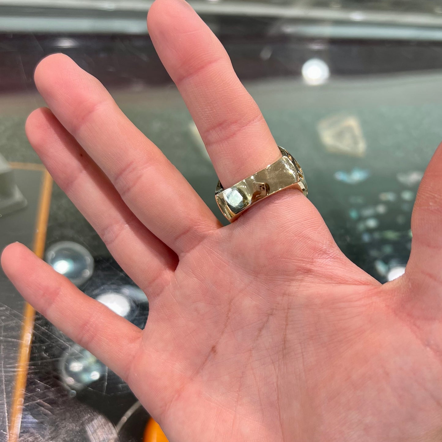 A yellow gold men's thug ring set with four fire agate stones resembling a spooky face.