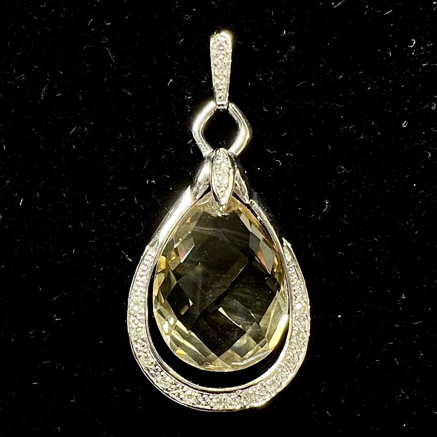 A ladies' white gold pendant set with diamonds and a faceted brilloette cut yellowish green heliodor beryl stone.