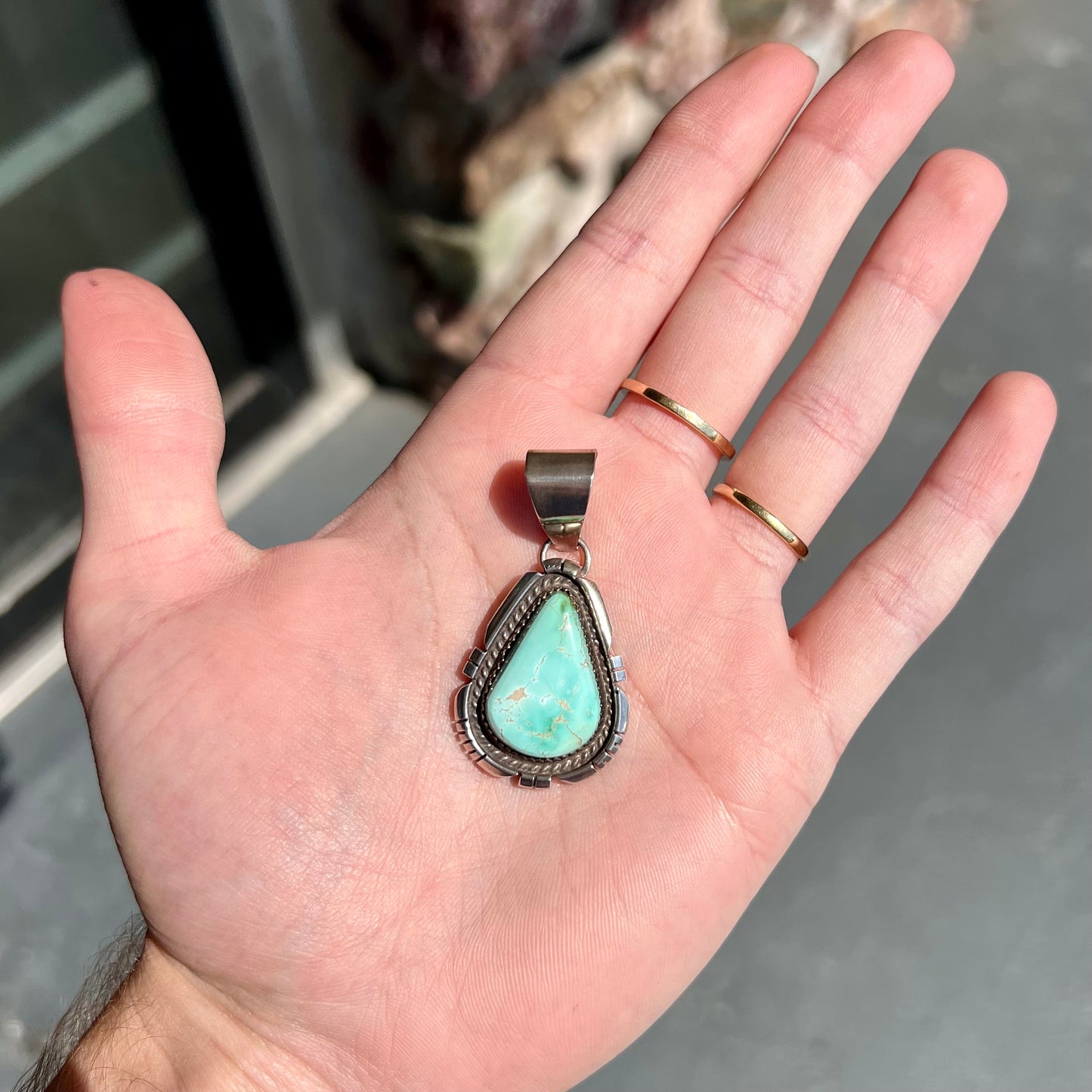 A sterling silver bezel set variscite stone pendant handmade by Navajo artist, Herman Lee.