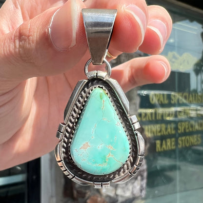 A sterling silver bezel set variscite stone pendant handmade by Navajo artist, Herman Lee.