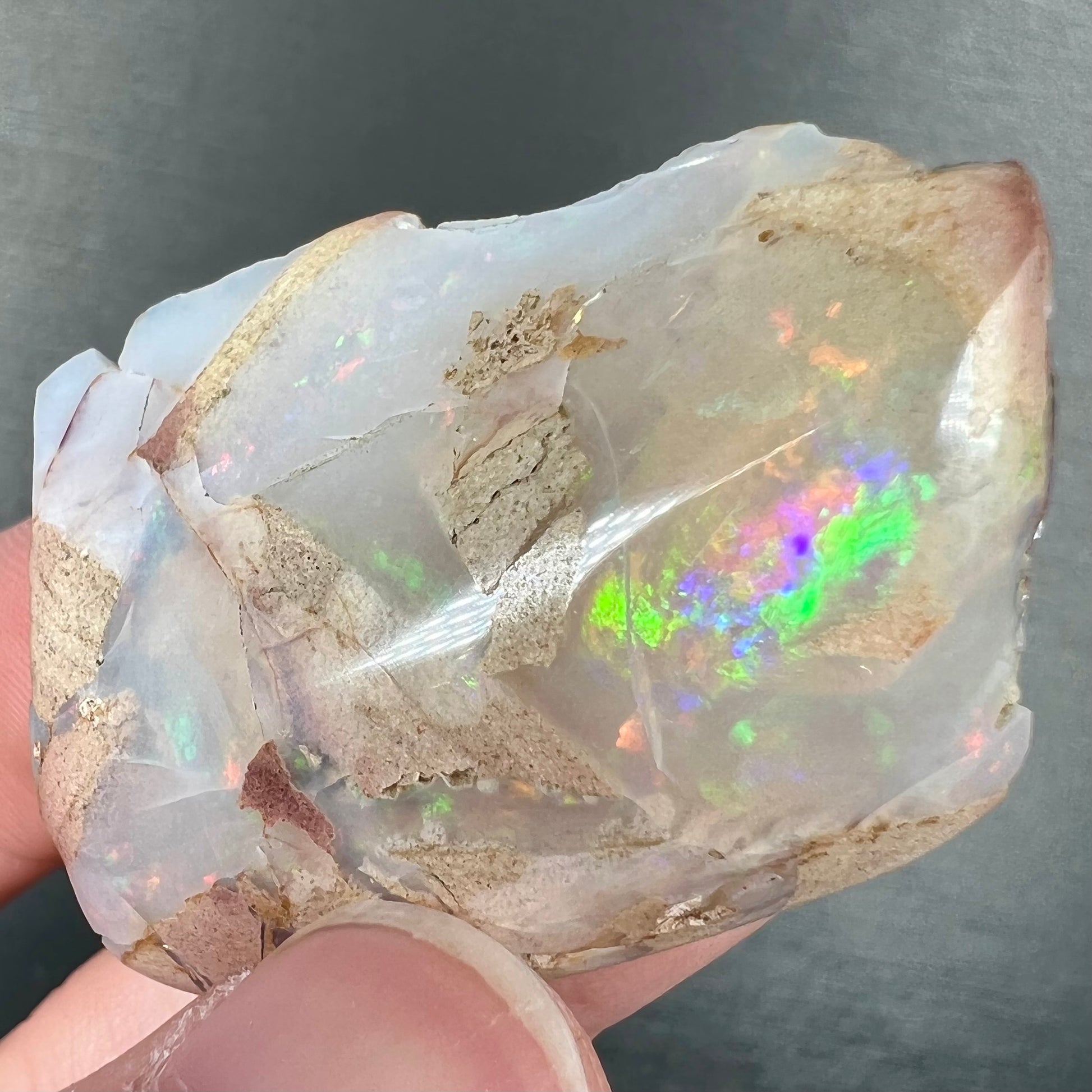 A loose, polished White Cliffs opal specimen.