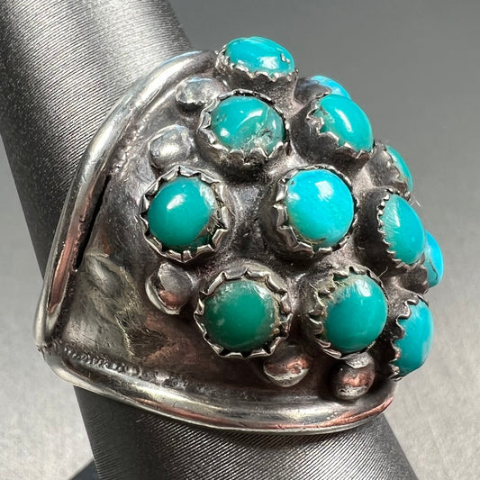 A handmade, unisex Hopi silver ring set with 14 round turquoise cabochons.