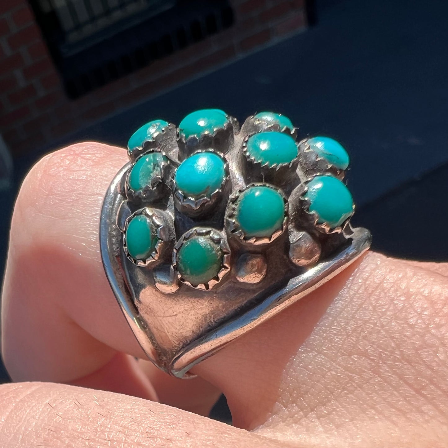 A handmade, unisex Hopi silver ring set with 14 round turquoise cabochons.