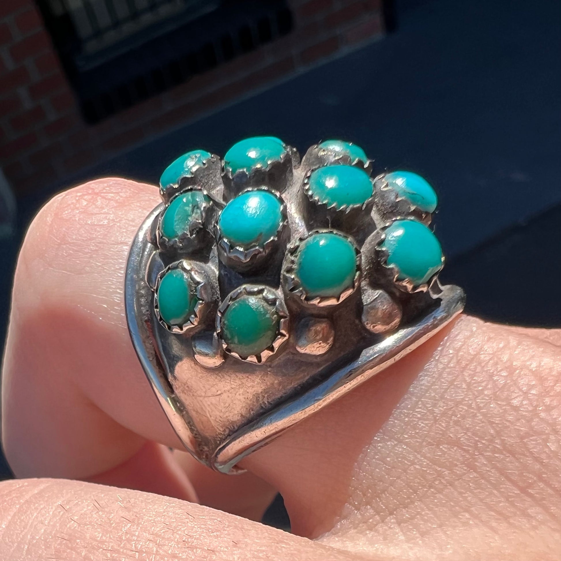 A handmade, unisex Hopi silver ring set with 14 round turquoise cabochons.