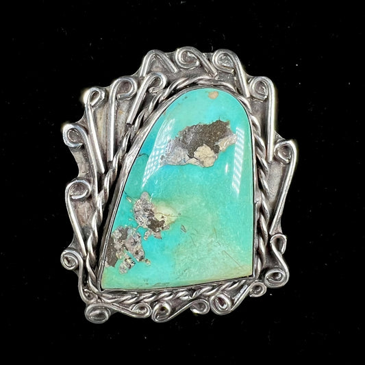 A sterling silver pendant made from greenish blue Royston turquoise, handmade by an unknown Hopi artist.