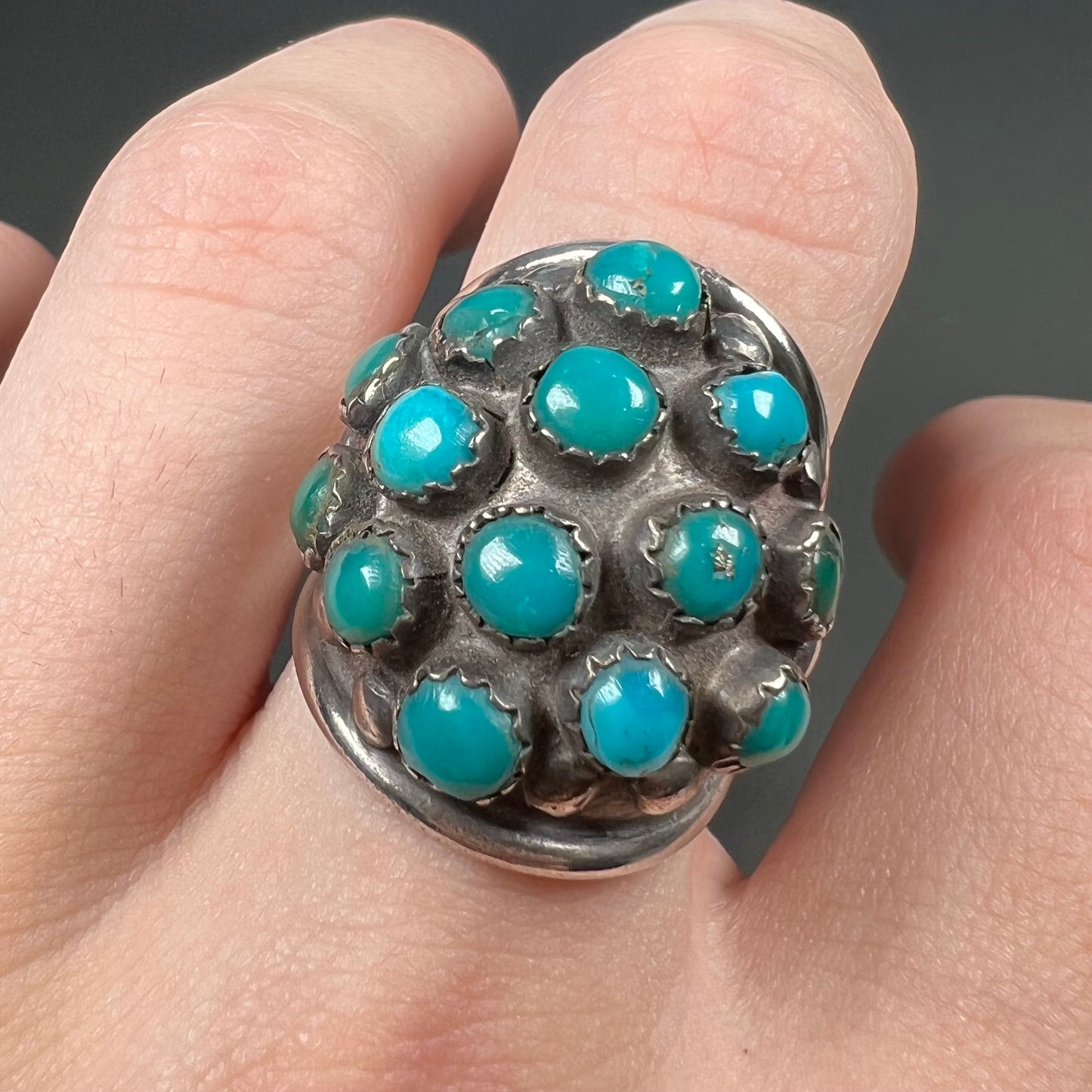 A handmade, unisex Hopi silver ring set with 14 round turquoise cabochons.