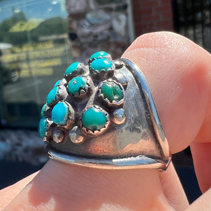 A handmade, unisex Hopi silver ring set with 14 round turquoise cabochons.
