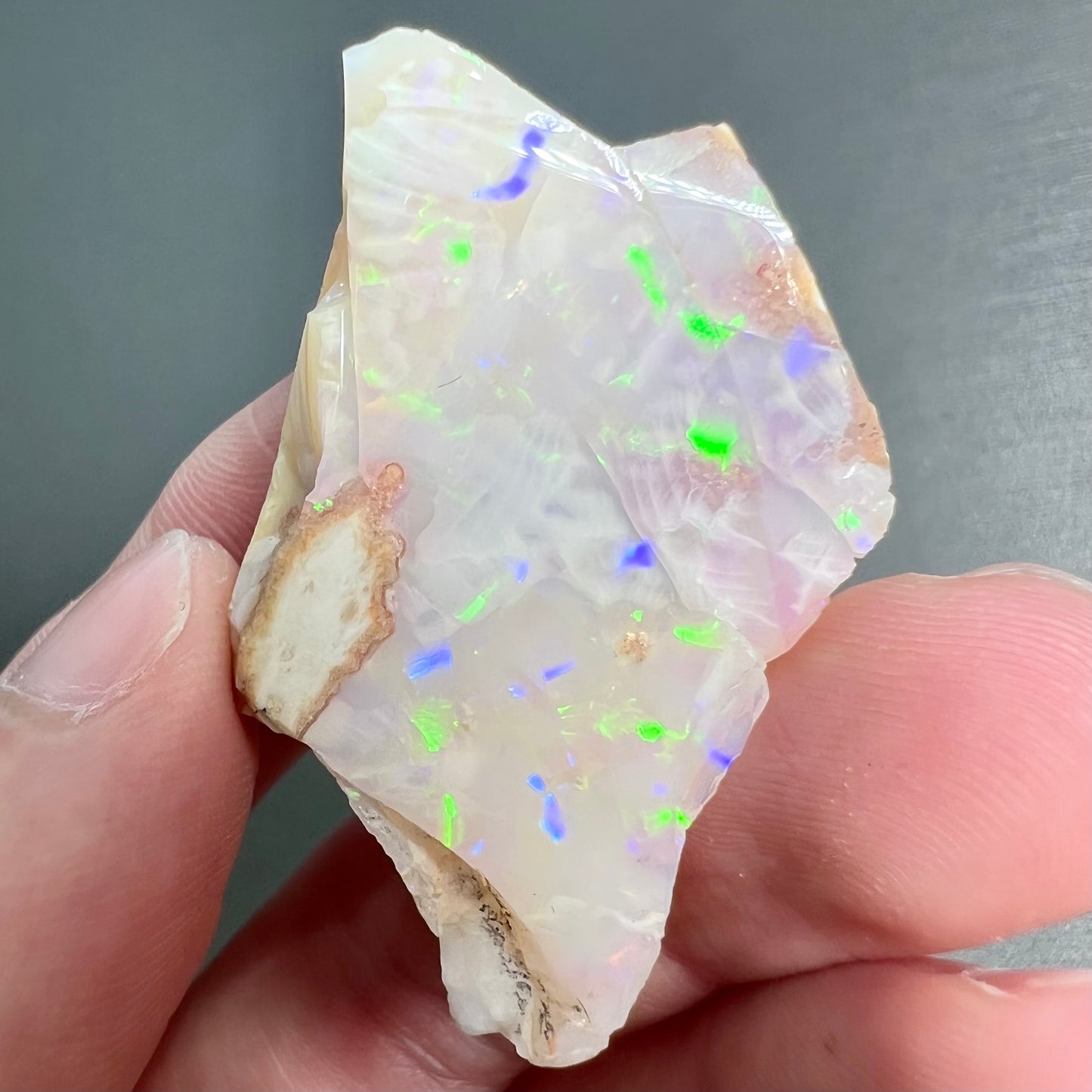 A loose, polished specimen of white crystal opal from Spencer, Idaho, USA.