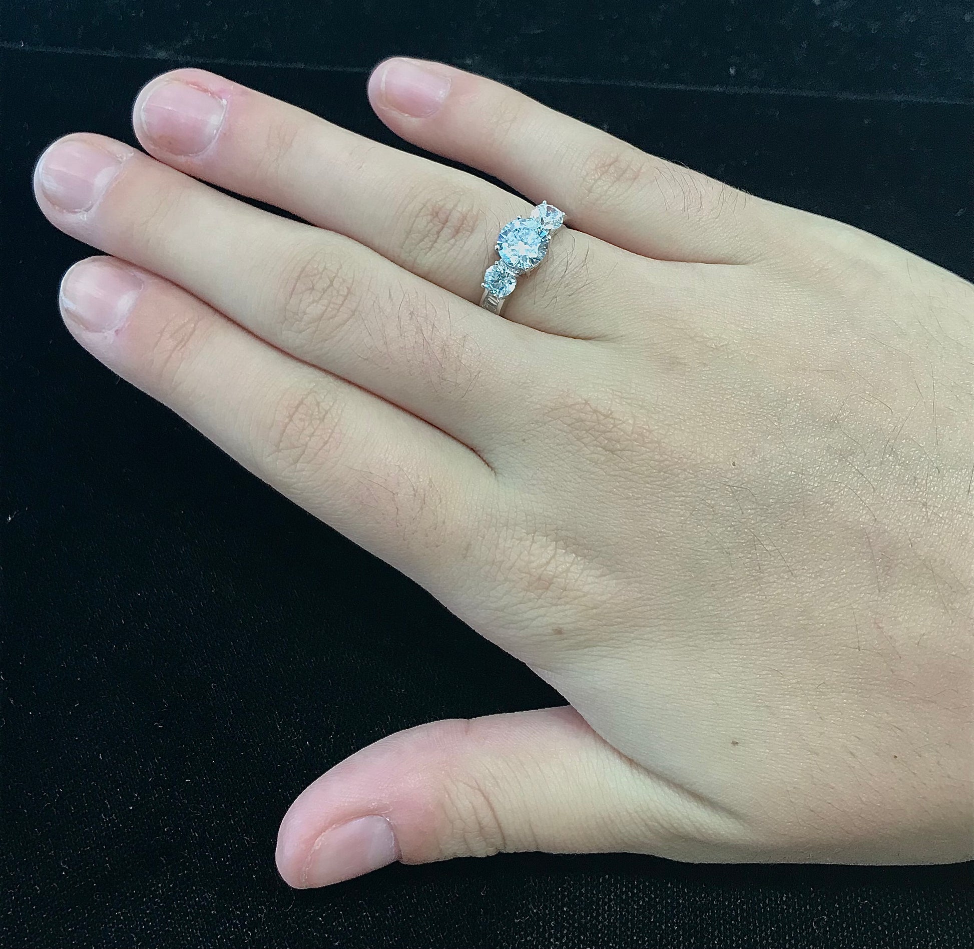 A sterling silver ring set with three round cut cubic zirconia stones.