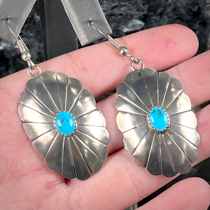 A pair of sterling silver concho turquoise dangle earrings.
