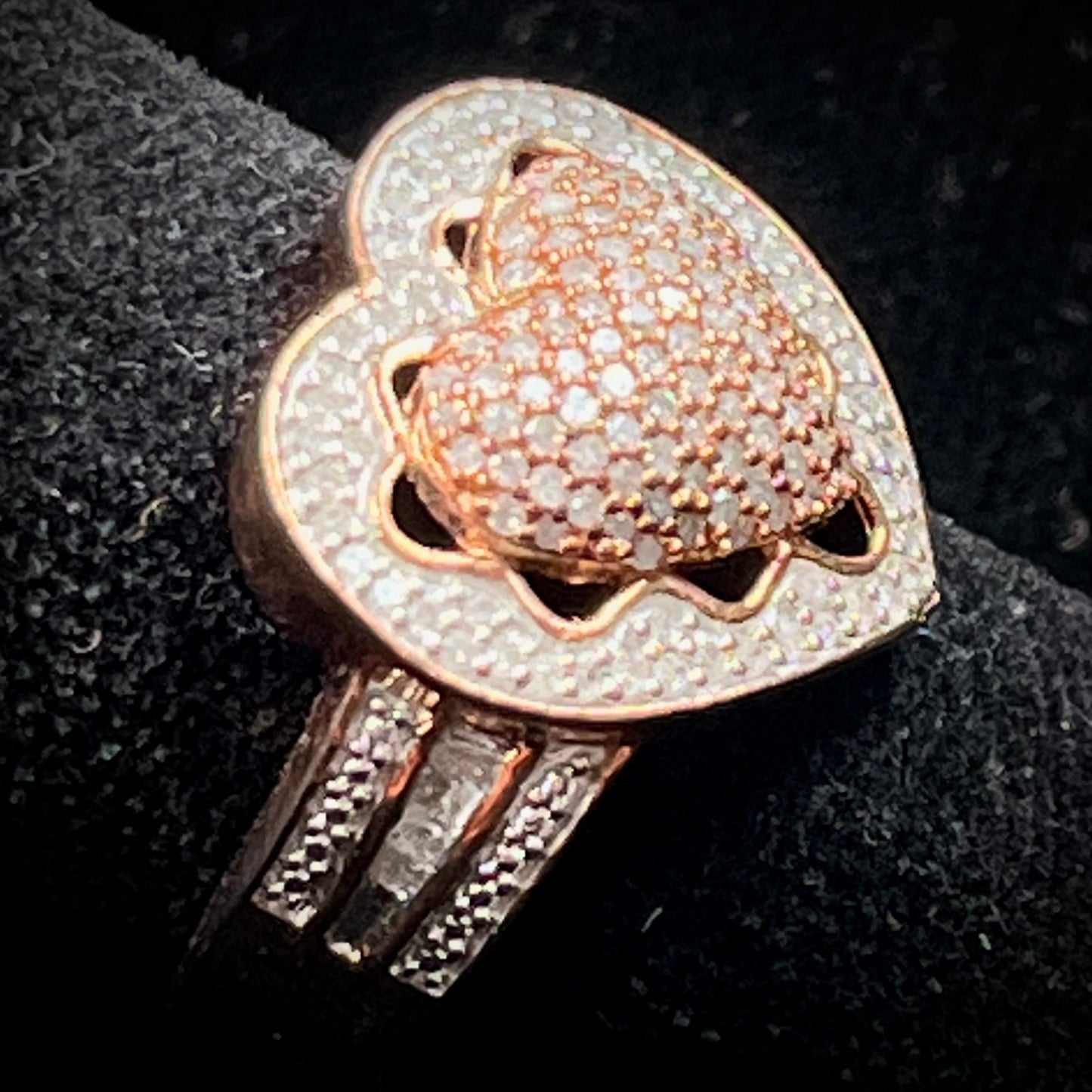 A rose colored metal ring pavé set with round and baguette cut diamonds.