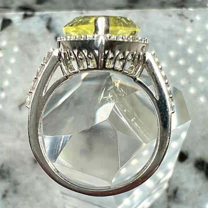 A pear shape lemon quartz set in a sterling silver and white topaz halo ring.