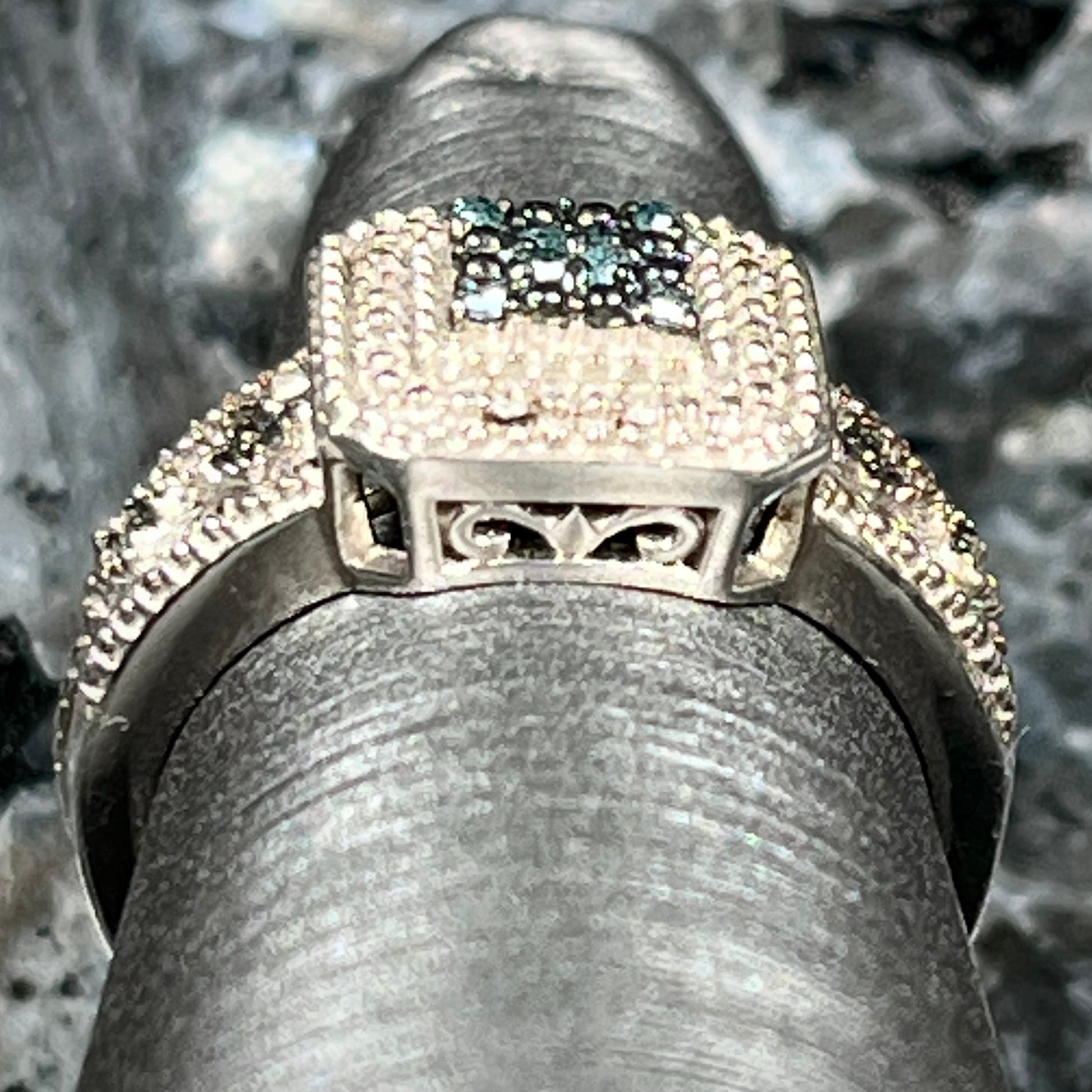 A sterling silver ring set with blue and white diamonds.