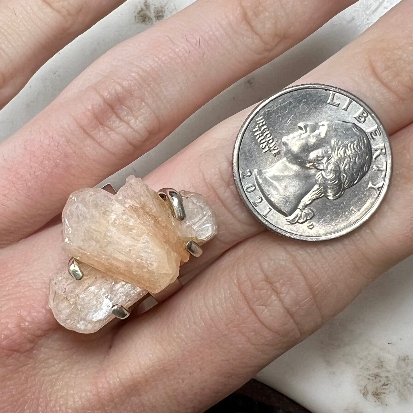 A sterling silver ring prong-set with a twinned moonstone crystal.