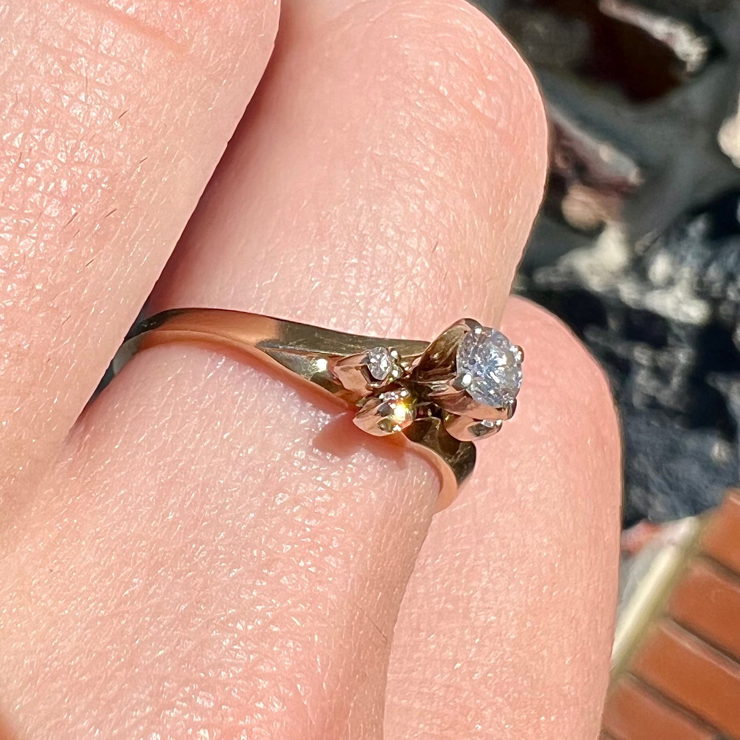 A yellow gold high-set diamond ring with four side diamonds.