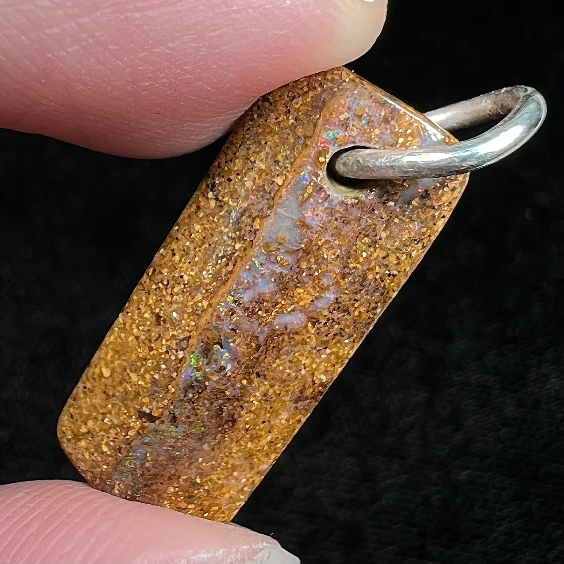 A boulder opal stone pendant with a sterling silver ring from Queensland, Australia.