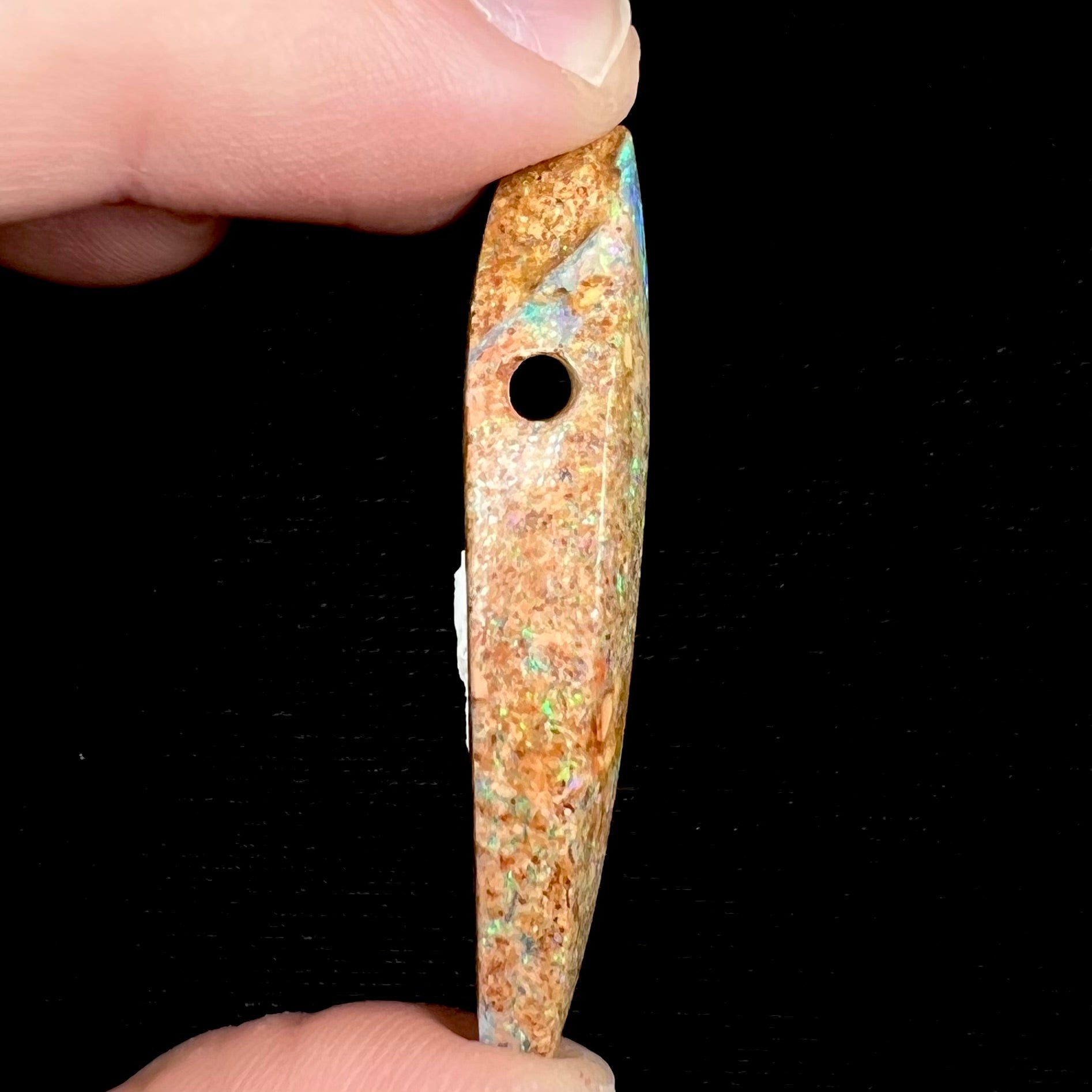 A polished, drilled pipe boulder opal bead.