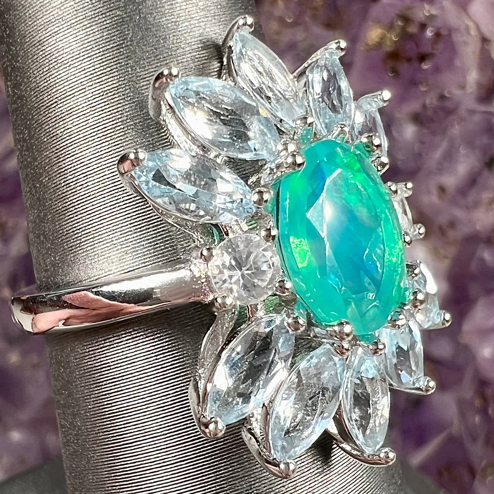 A faceted oval cut blue Ethiopian fire opal set in a sterling silver ring with marquise cut blue topaz stones.