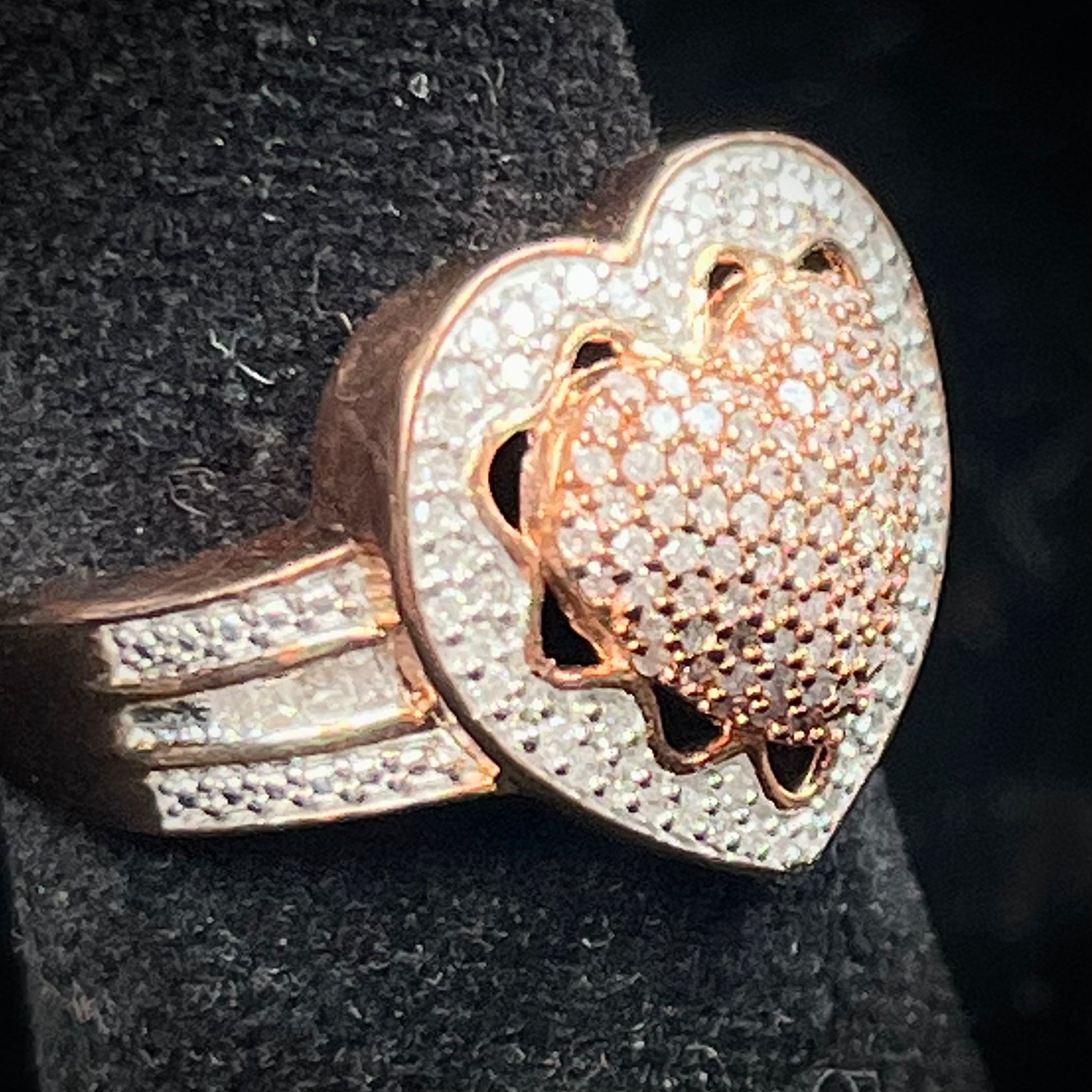 A rose colored metal ring pavé set with round and baguette cut diamonds.