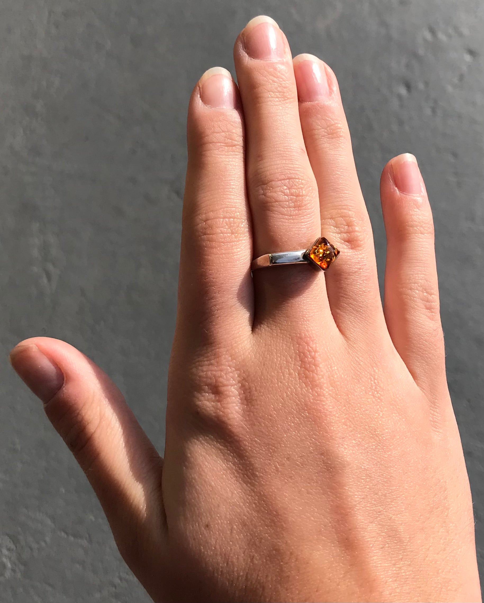 Square shaped Baltic Amber cabochon set in a unique sterling silver ring.