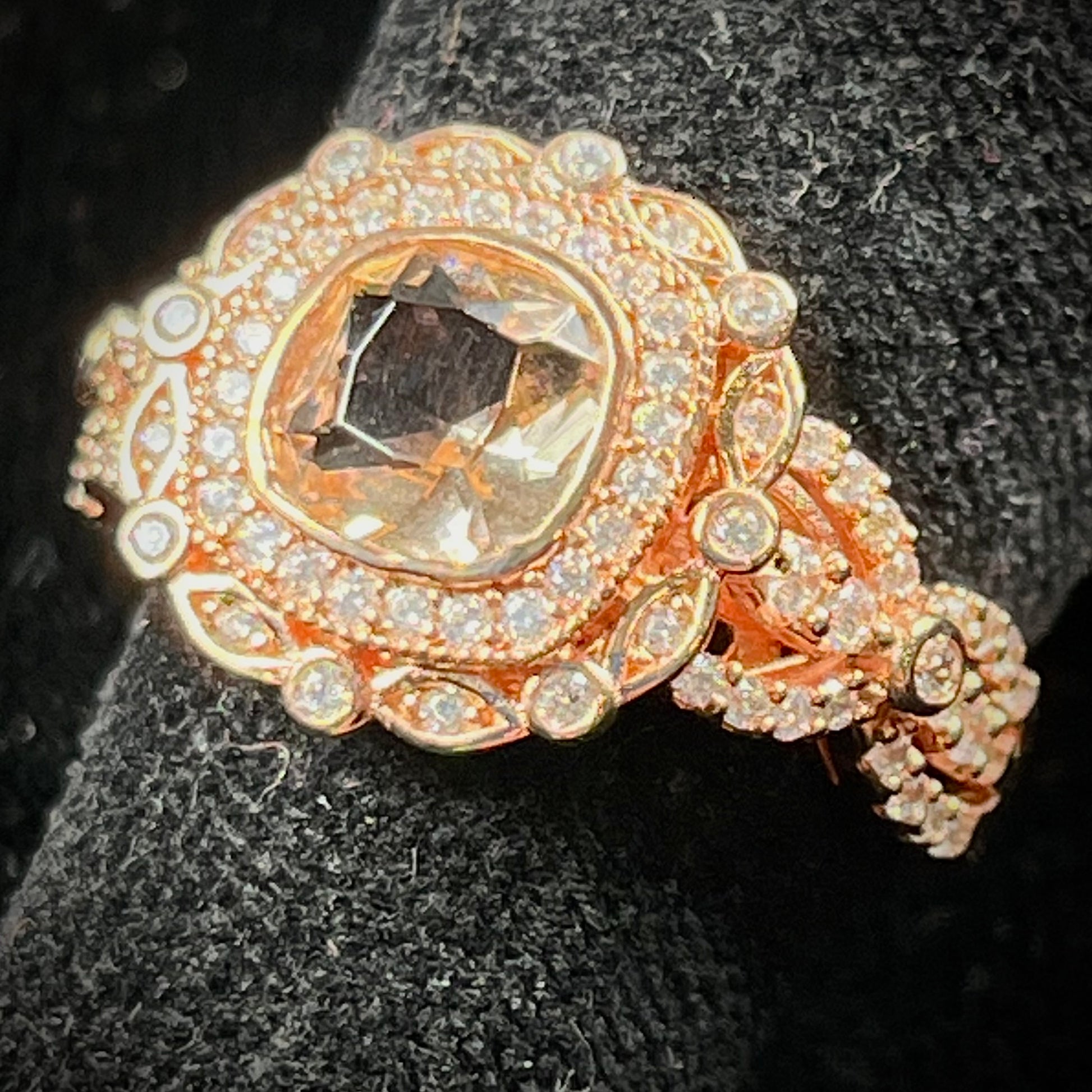 A rose gold plated ring set with a cushion cut morganite stone surrounded by cubic zirconia halos.