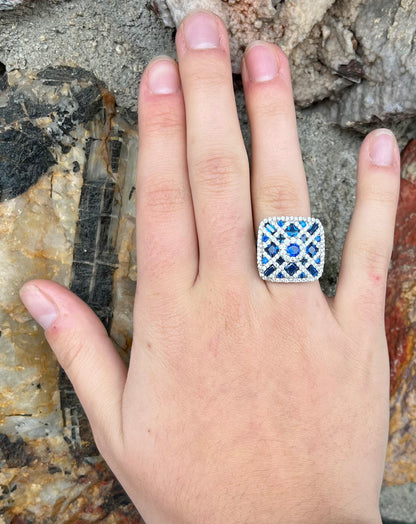A sterling silver blue and white synthetic stone ring.  The ring strongly resembles a blueberry pie.