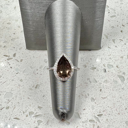A pear shape smoky quartz set in a sterling silver and CZ halo ring.