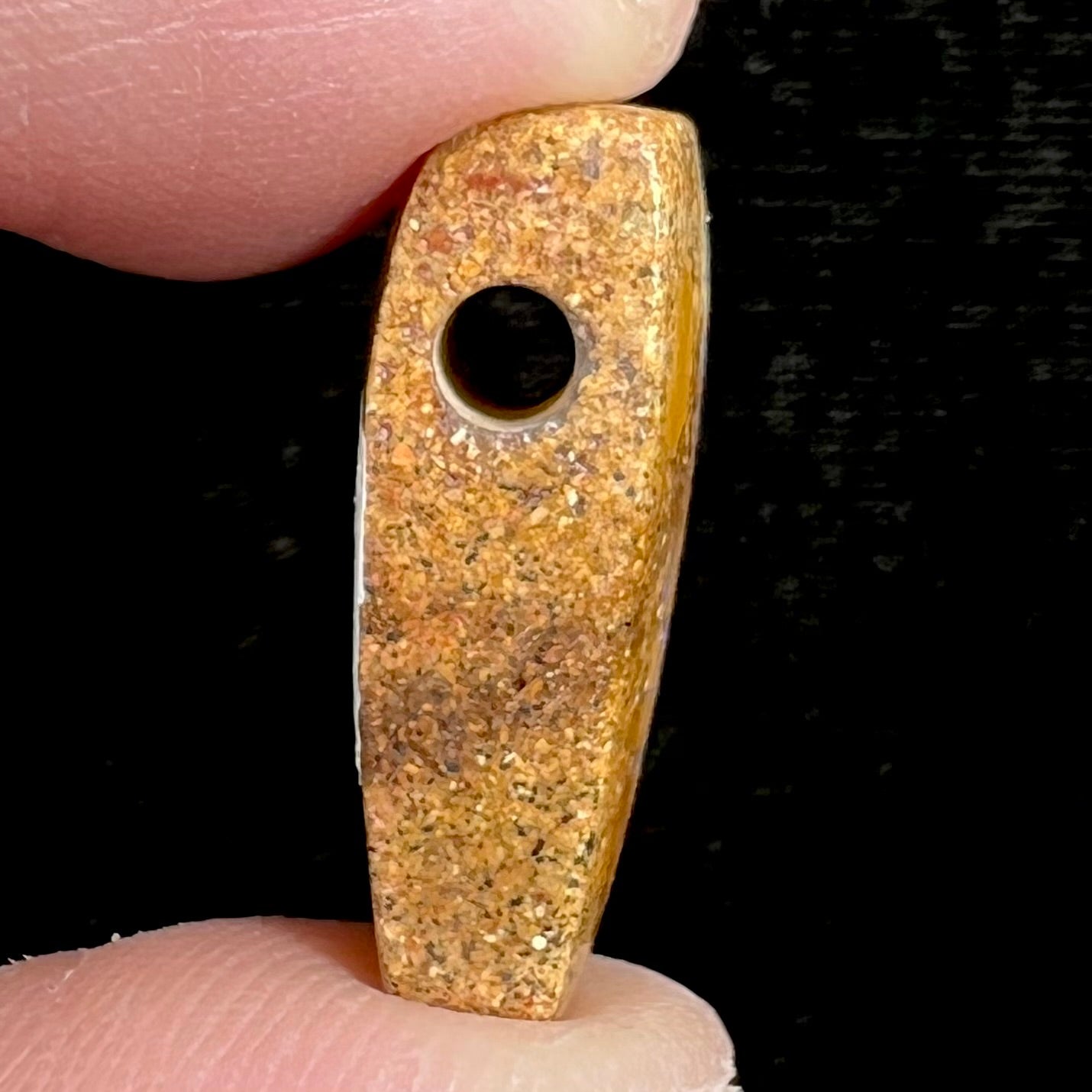 A polished, drilled pipe boulder opal bead.