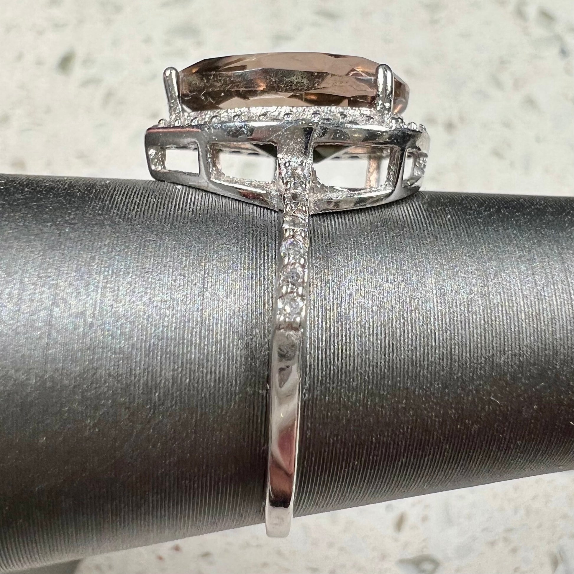 A pear shape smoky quartz set in a sterling silver and CZ halo ring.