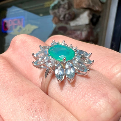 A faceted oval cut blue Ethiopian fire opal set in a sterling silver ring with marquise cut blue topaz stones.