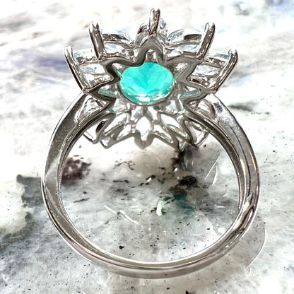 A faceted oval cut blue Ethiopian fire opal set in a sterling silver ring with marquise cut blue topaz stones.