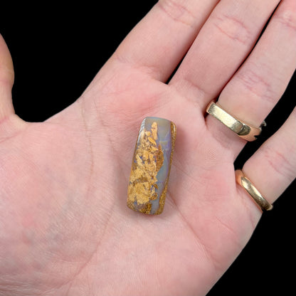 A polished, drilled pipe boulder opal bead.
