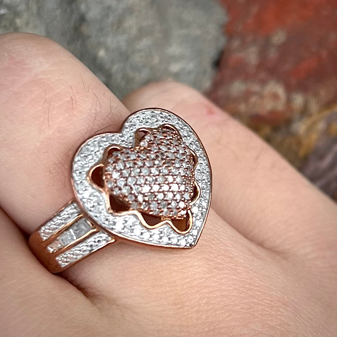 A rose colored metal ring pavé set with round and baguette cut diamonds.