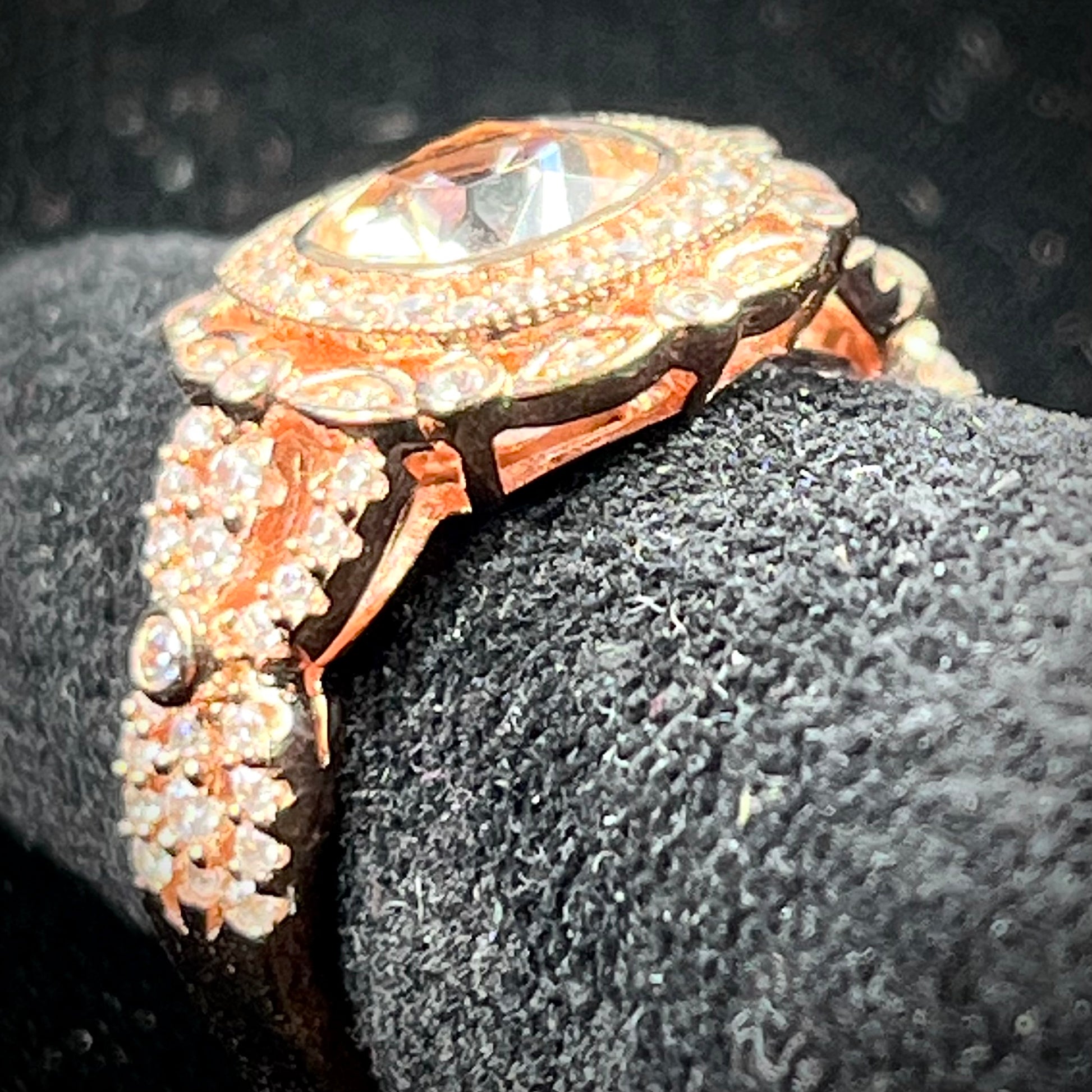 A rose gold plated ring set with a cushion cut morganite stone surrounded by cubic zirconia halos.