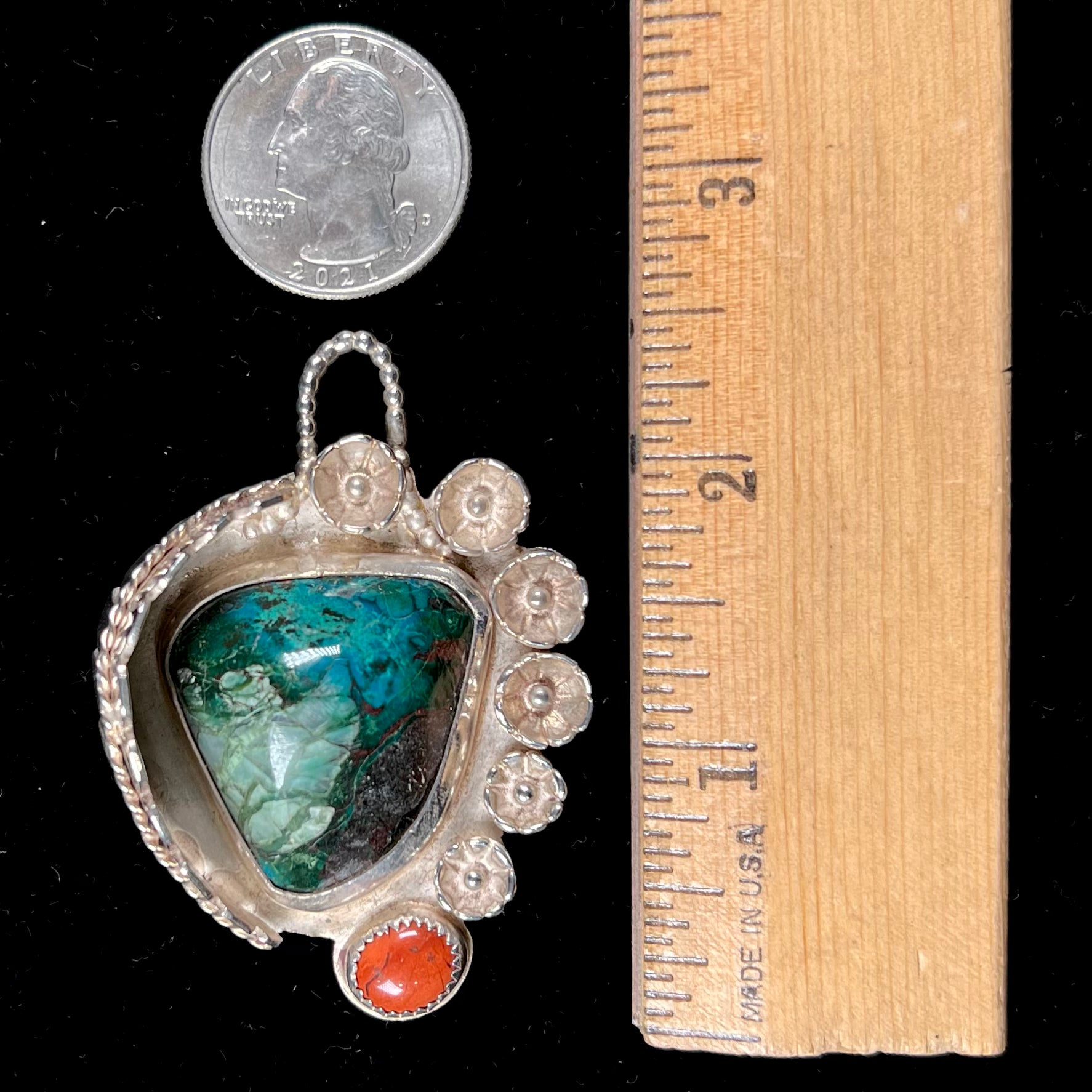 A sterling silver Navajo-style pendant set with chrysocolla and red jasper stones.