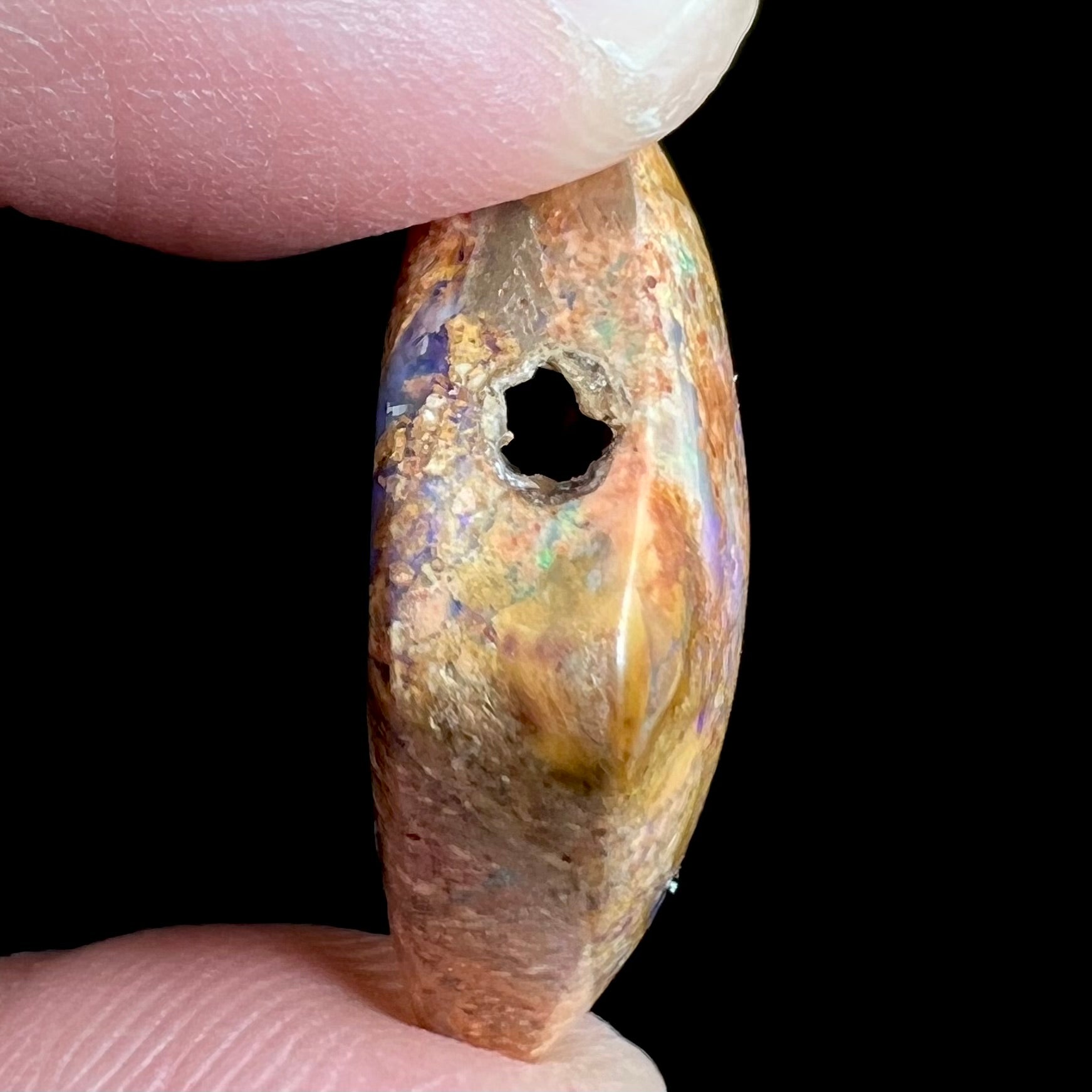 A polished, drilled pipe boulder opal bead.