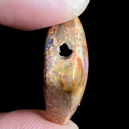 A polished, drilled pipe boulder opal bead.