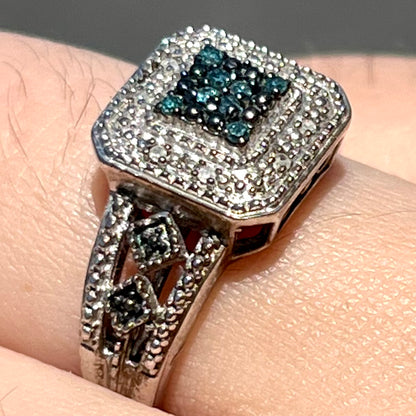 A sterling silver ring set with blue and white diamonds.