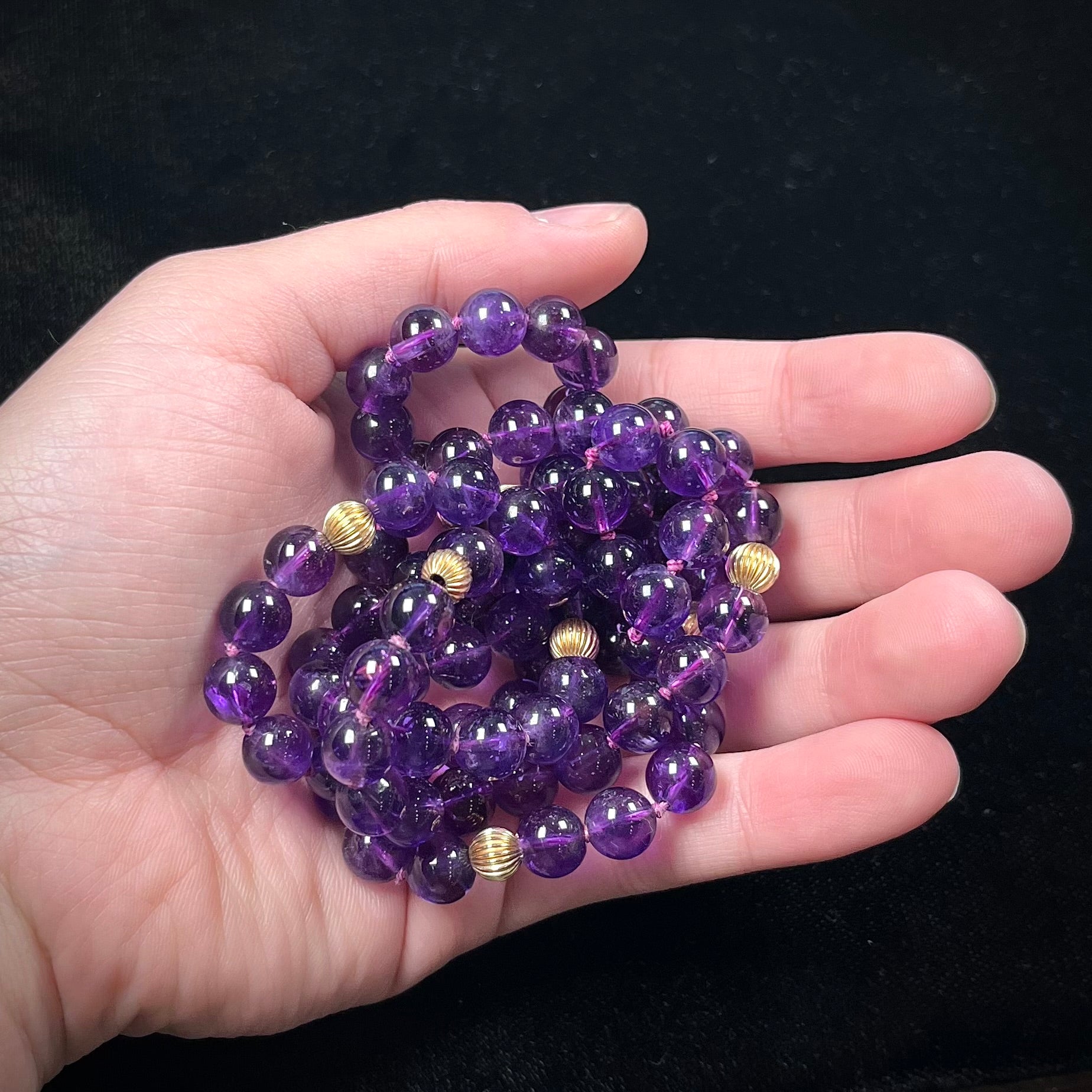 A beaded necklace made with round amethyst and 14k yellow gold beads.