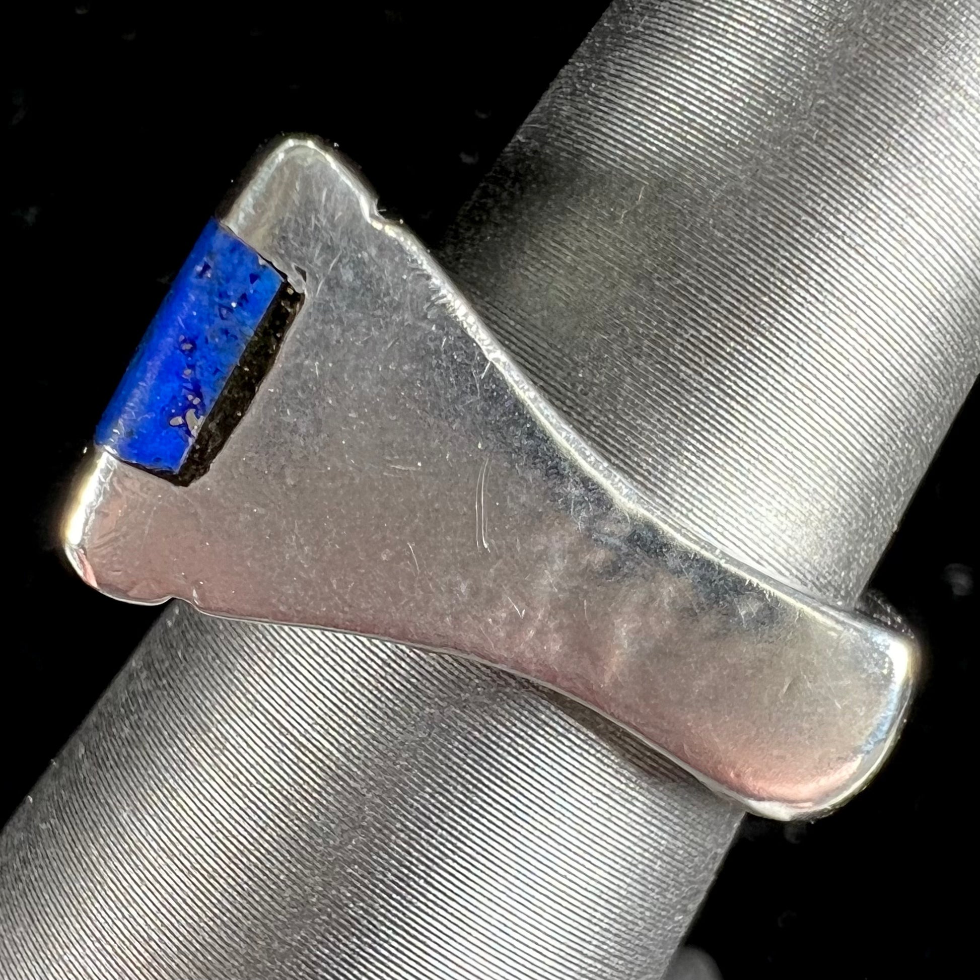 A sterling silver ring inlaid with a piece of lapis lazuli.  A small crack runs through the piece of lapis.