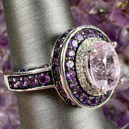 A sterling silver oval cut kunzite ring set with a double halo of round cut CZ and amethysts.