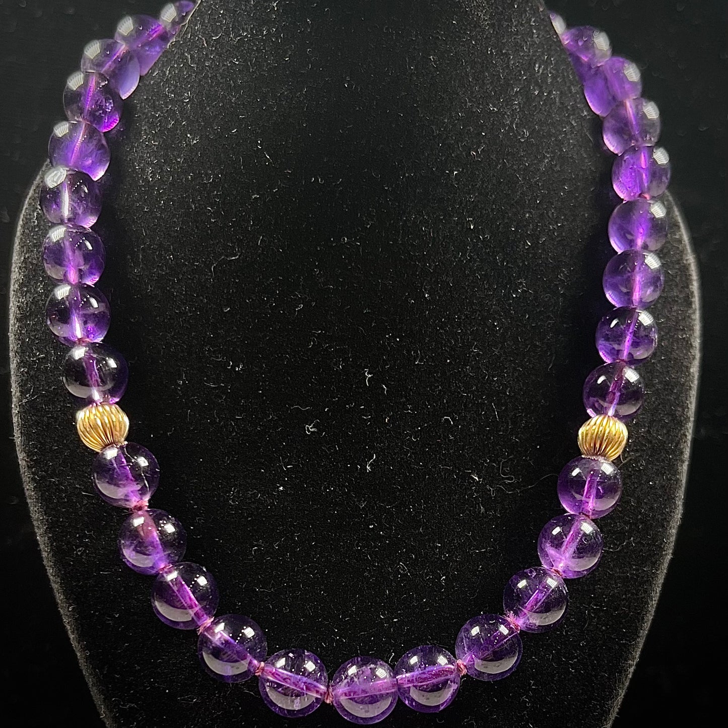 A beaded necklace made with round amethyst and 14k yellow gold beads.