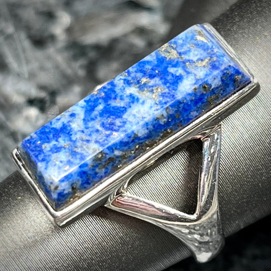 A split shank silver rectangular cabochon cut lapis lazuli ring.