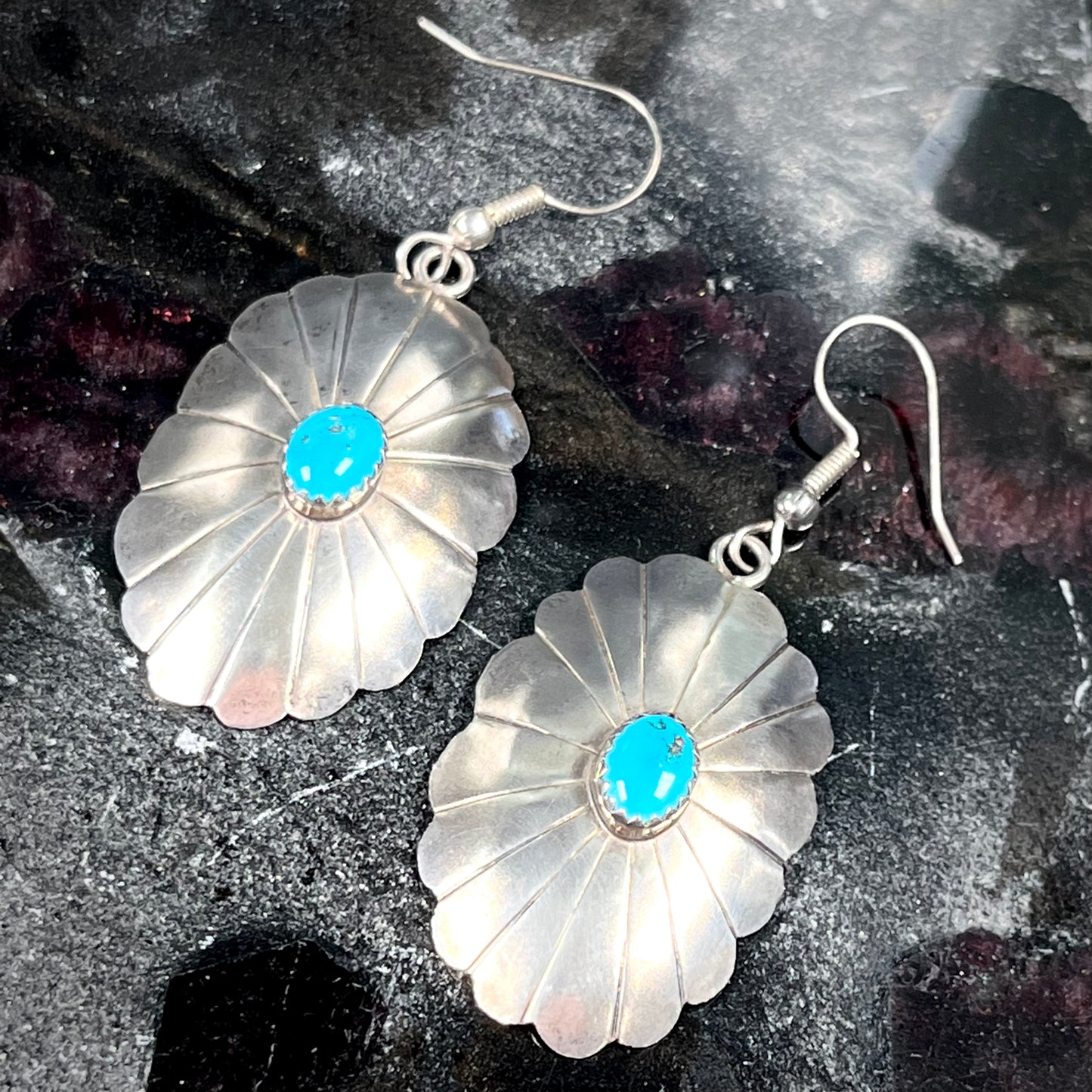 A pair of sterling silver concho turquoise dangle earrings.