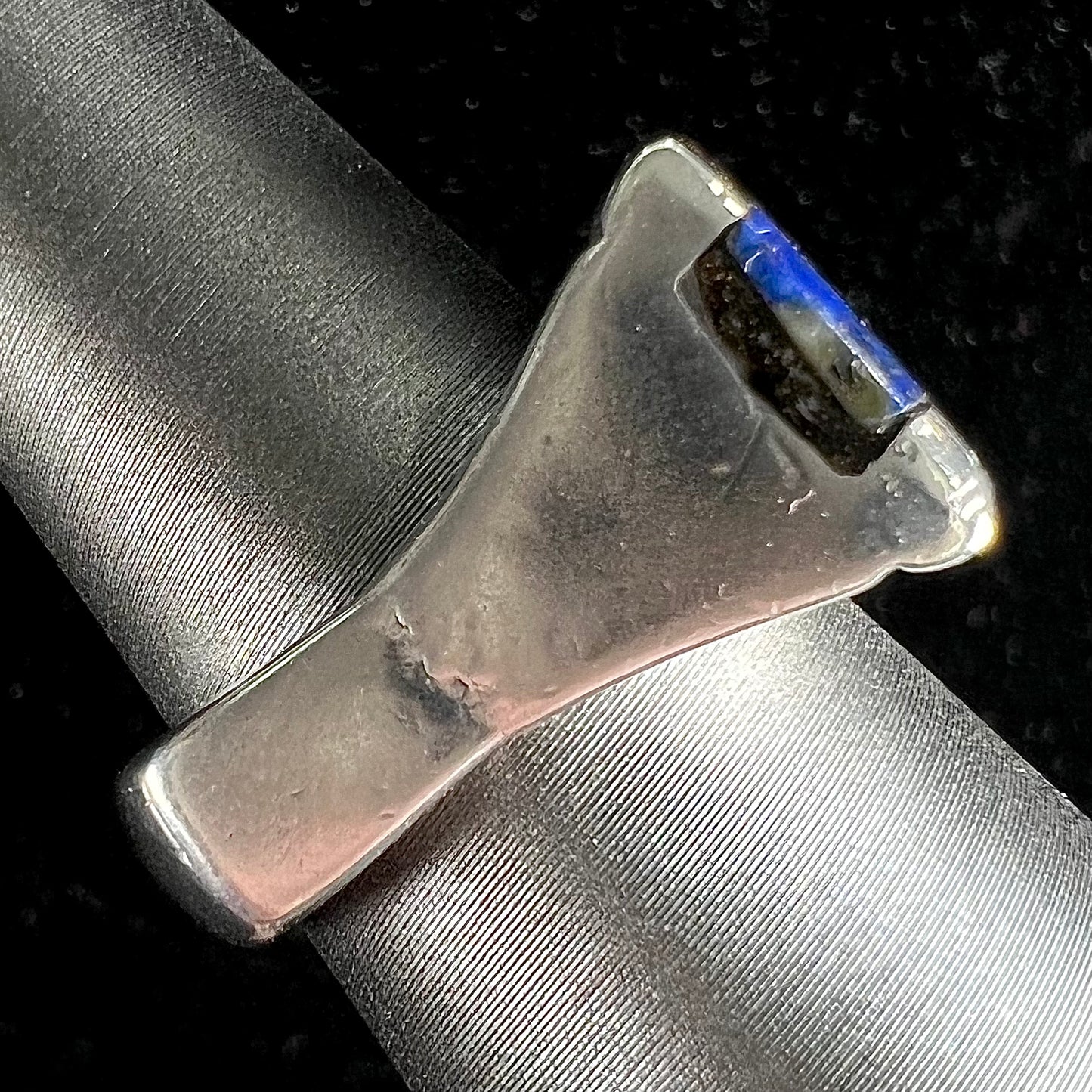 A sterling silver ring inlaid with a piece of lapis lazuli.  A small crack runs through the piece of lapis.