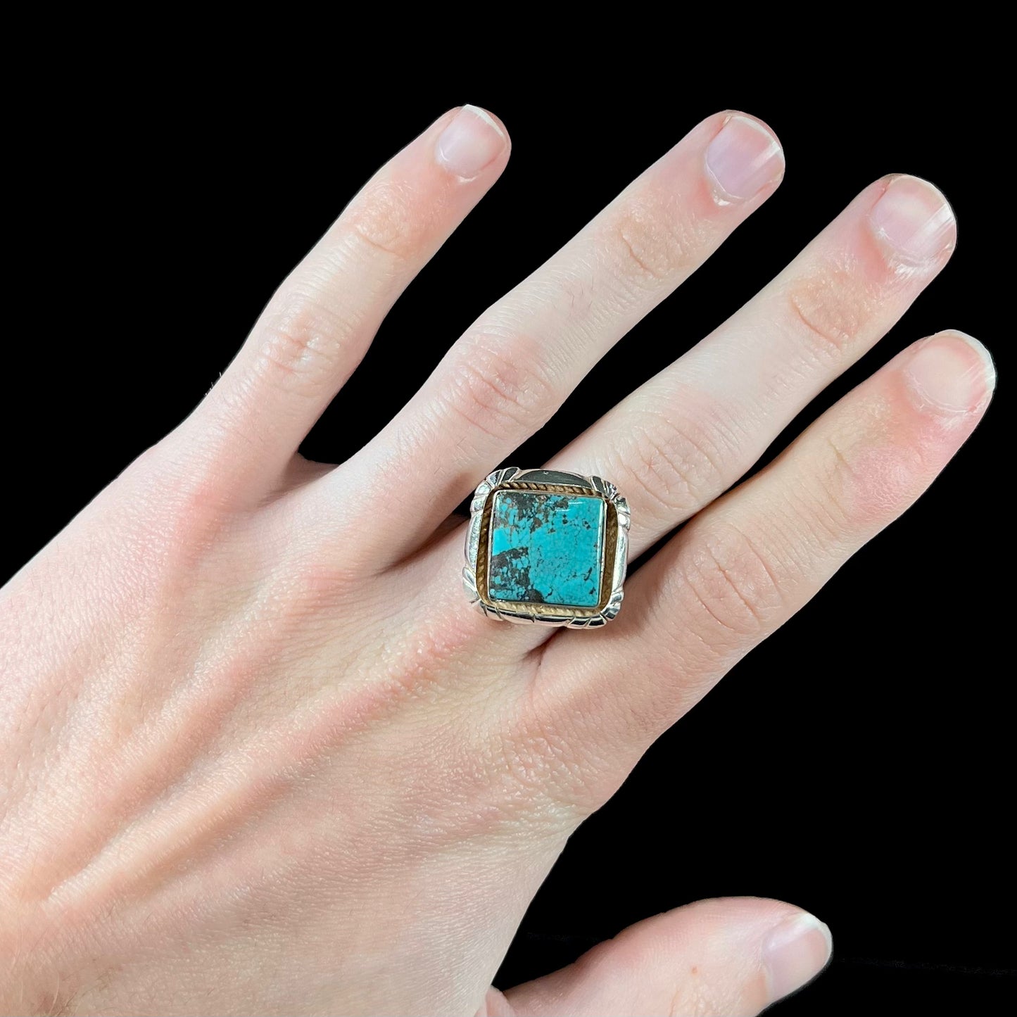 A handmade sterling silver, unisex, likely Navajo ring set with Tibetan turquoise.