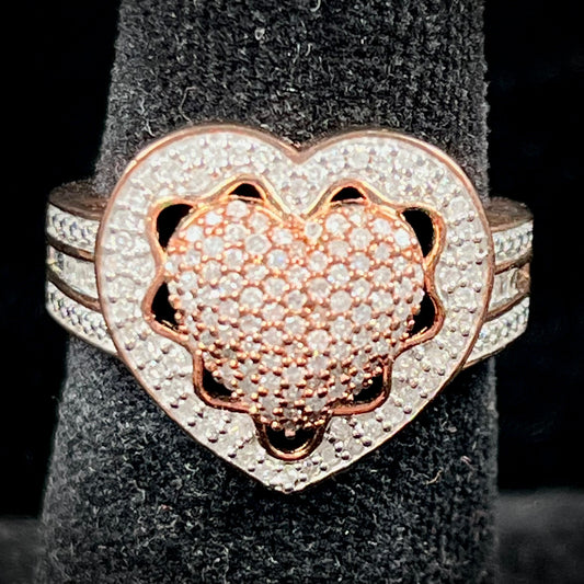 A rose colored metal ring pavé set with round and baguette cut diamonds.