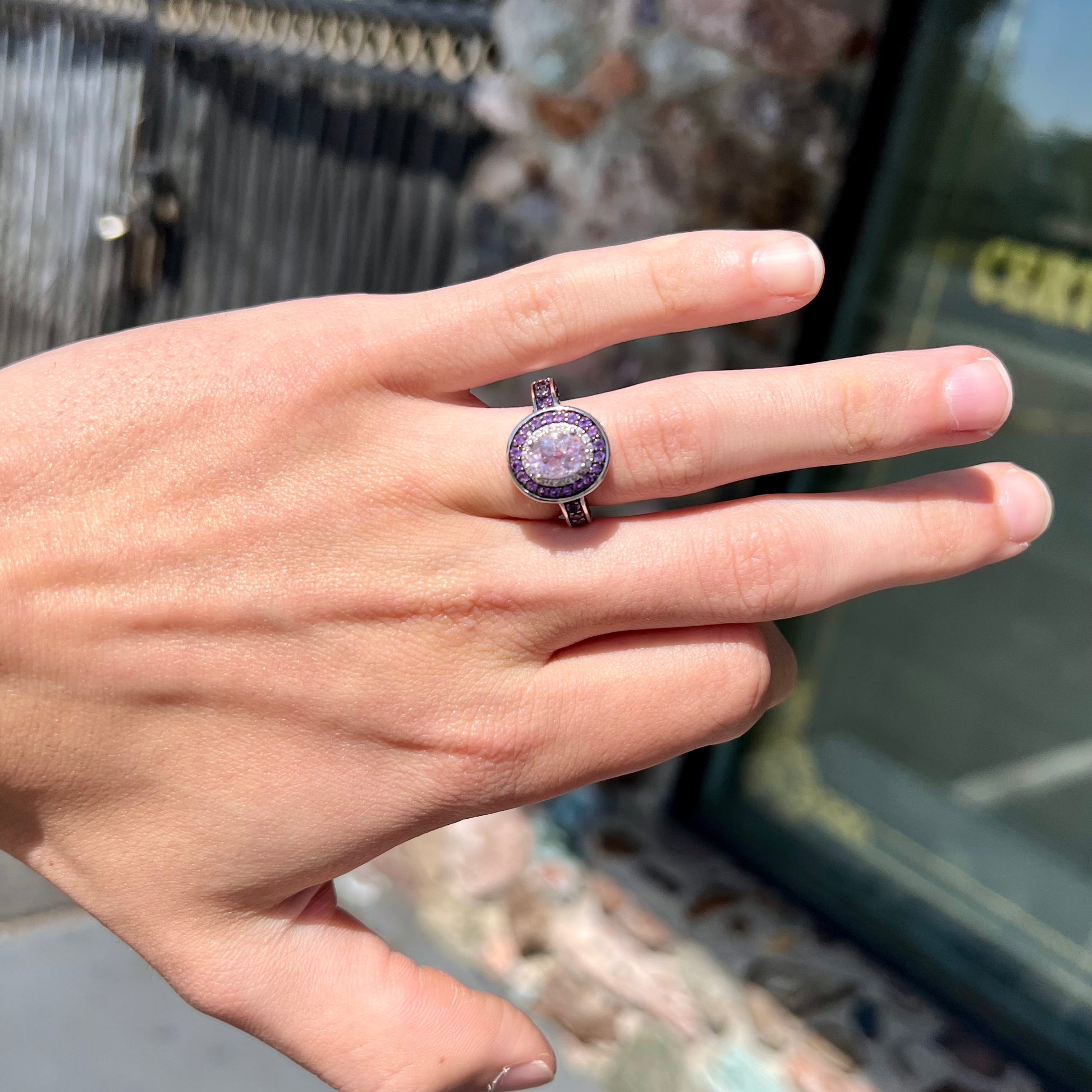 A sterling silver oval cut kunzite ring set with a double halo of round cut CZ and amethysts.